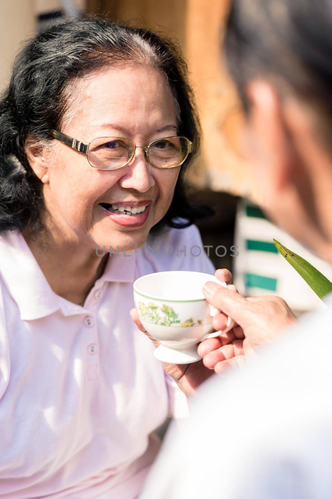 Smiling woman taking coffee cup from her husband