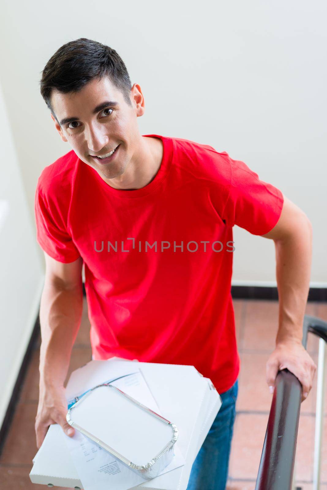 Portrait of happy pizza delivery man with food parcels