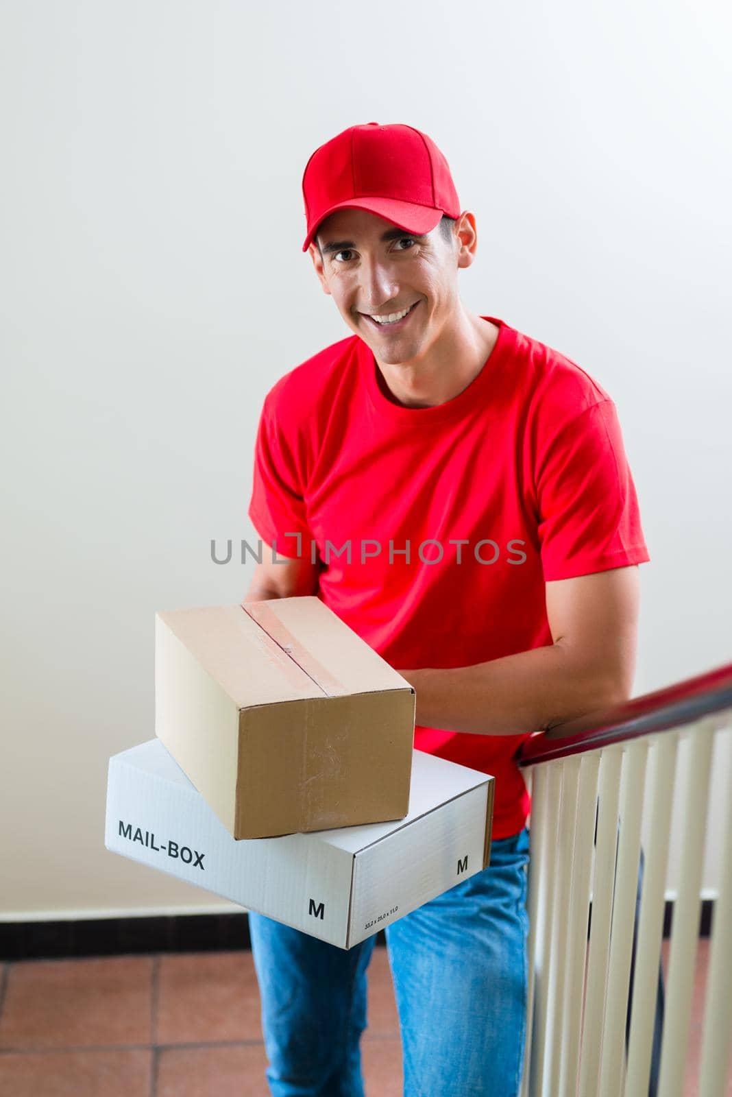 Delivery man holding two cardboard boxes by Kzenon