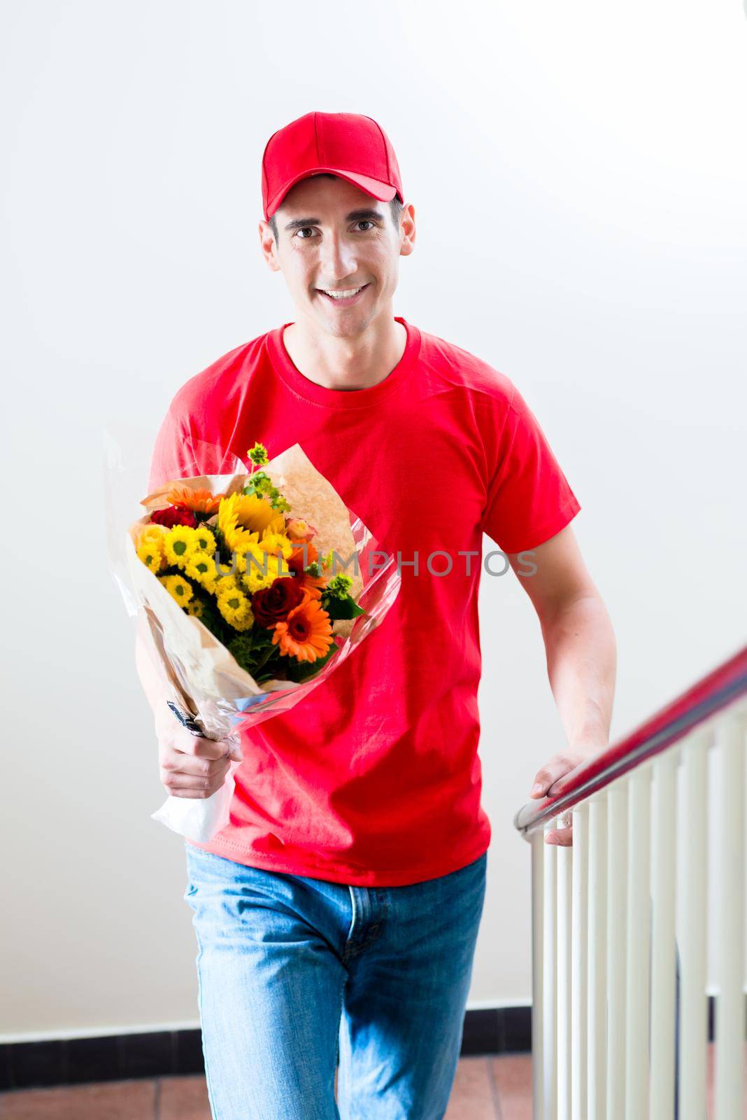 Portrait of happy delivery man with beautiful flower bouquet gift