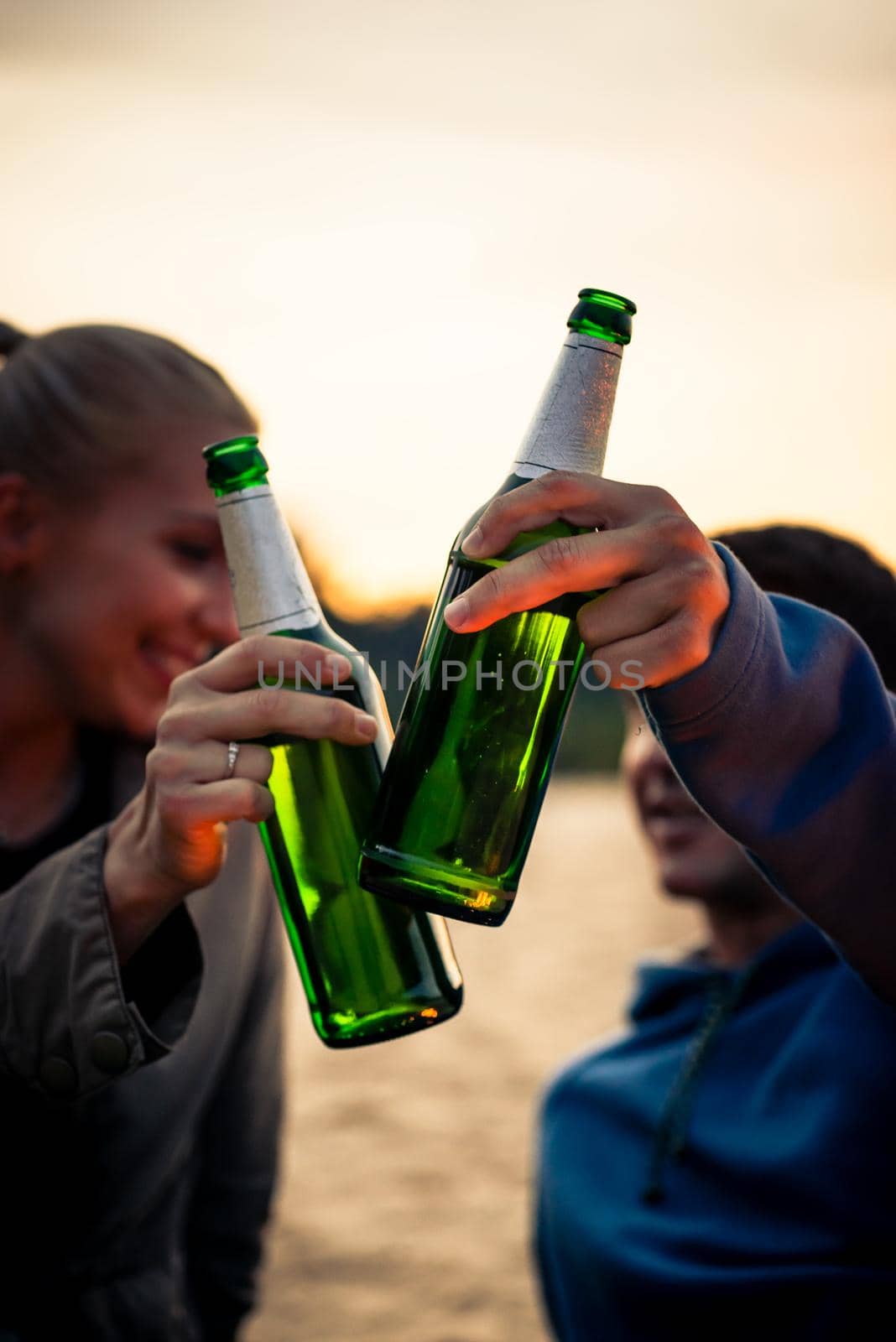 Close-up of couple holding green alcohol bottles celebrating