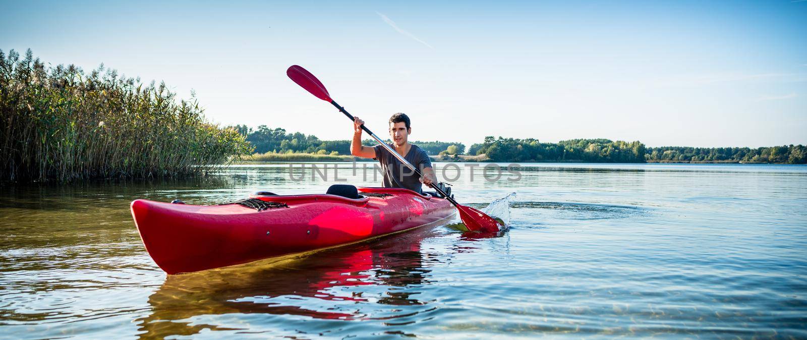 Man explore the lake on kayak by Kzenon