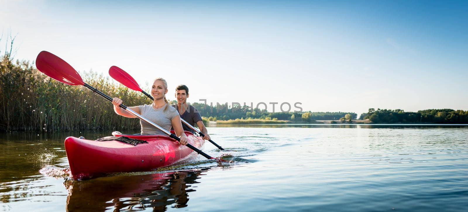 Beautiful couple sailing kayak on lake by Kzenon