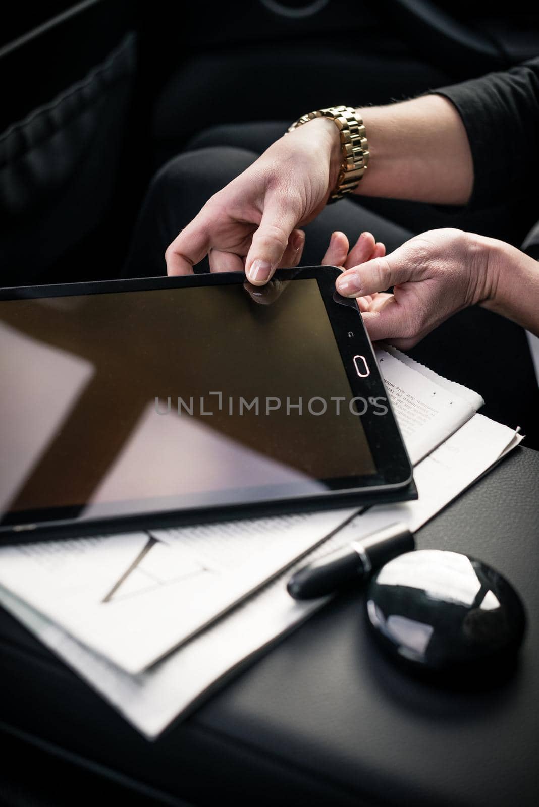 Businesswoman taking digital tablet in car by Kzenon