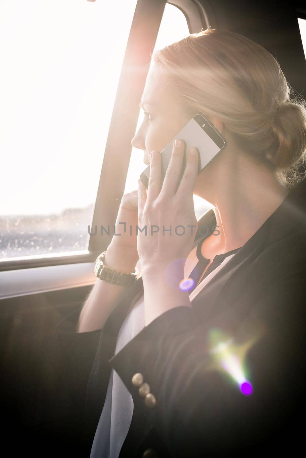 Businesswoman on call in car by Kzenon