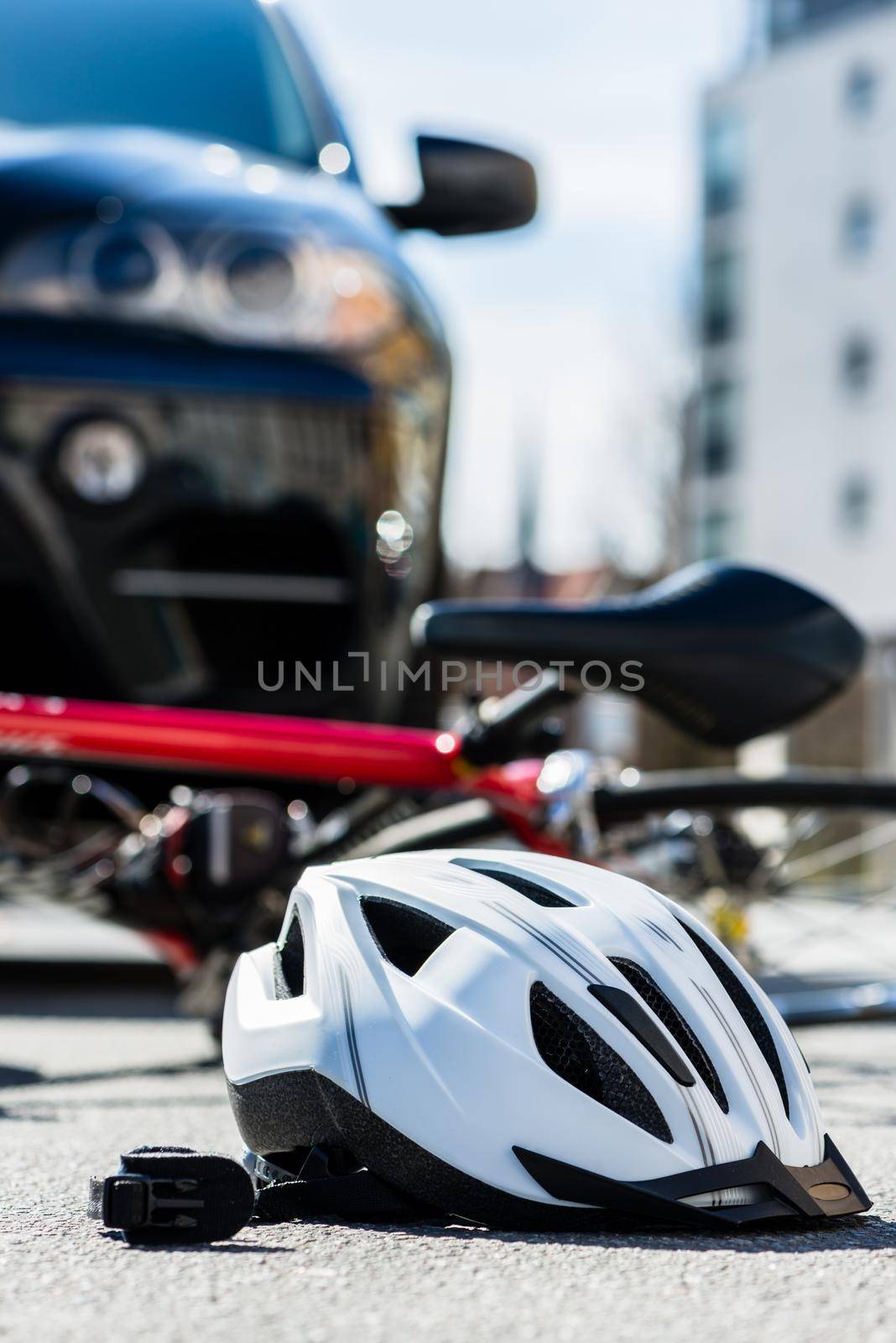 Close-up of a bicycling helmet on the asphalt after car accident by Kzenon
