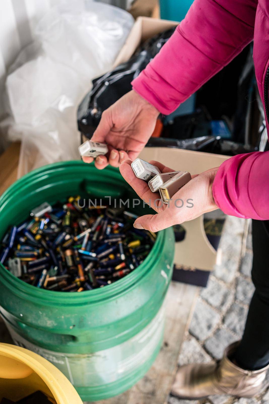 Batteries being disposed of in recycling center, hands of woman