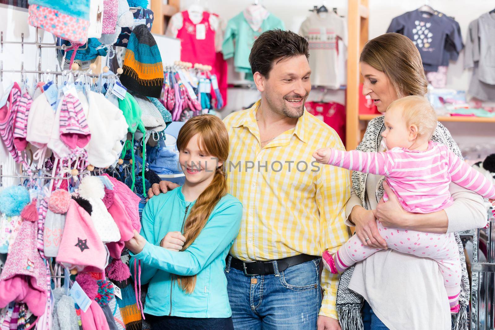 Portrait of happy family shopping together in retail store