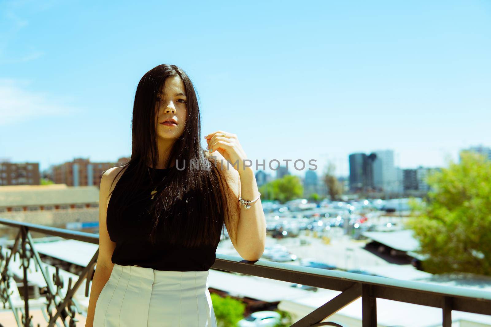 Young girl leaning on a railing with the city of madrid in the background. by xavier_photo