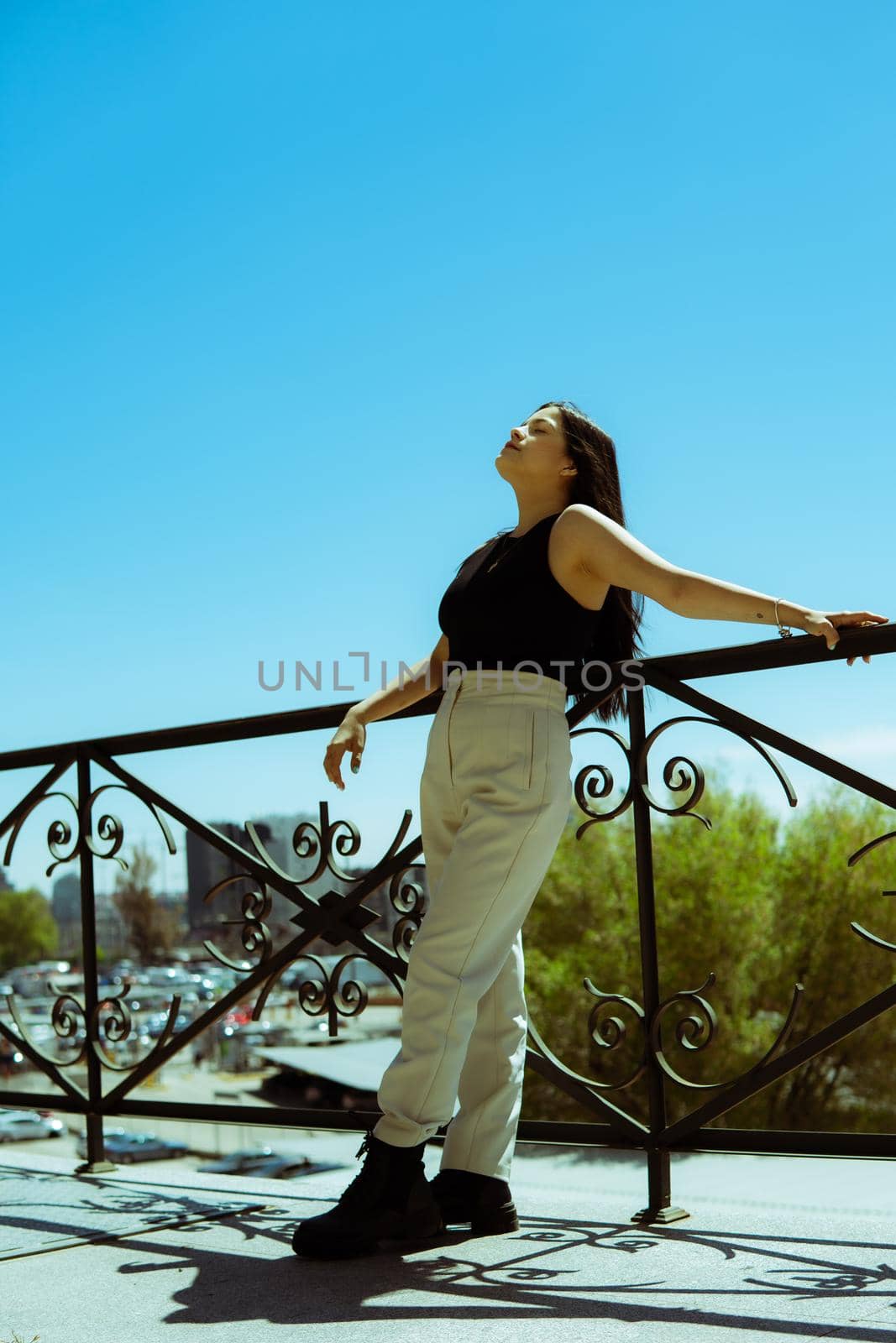 Young girl leaning on a railing with the city of madrid in the background.