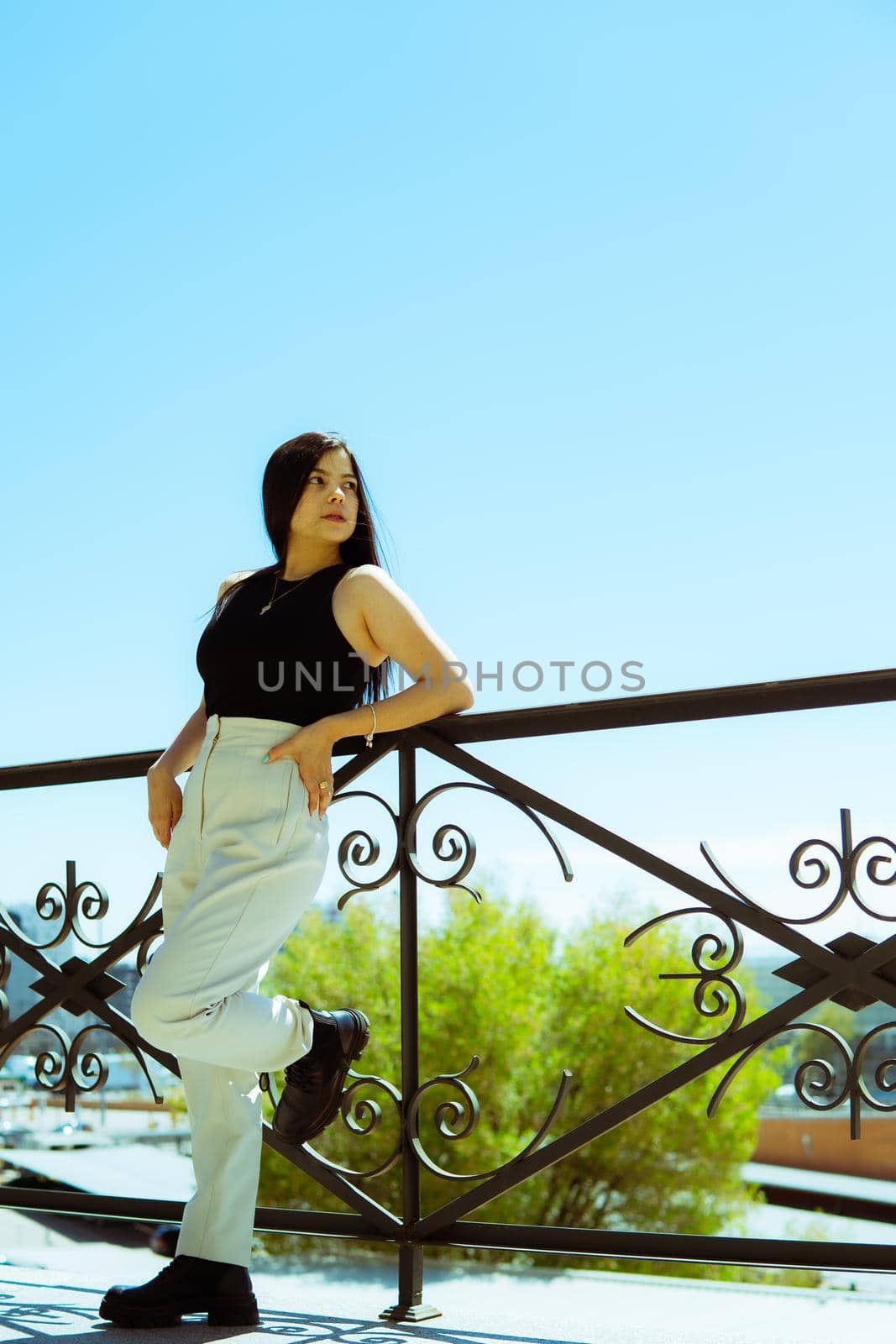 Young girl leaning on a railing with the city of madrid in the background. by xavier_photo