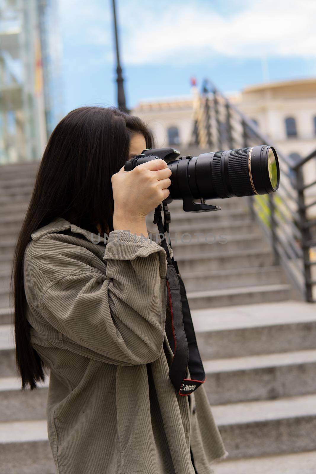Young girl taking pictures with a big camera