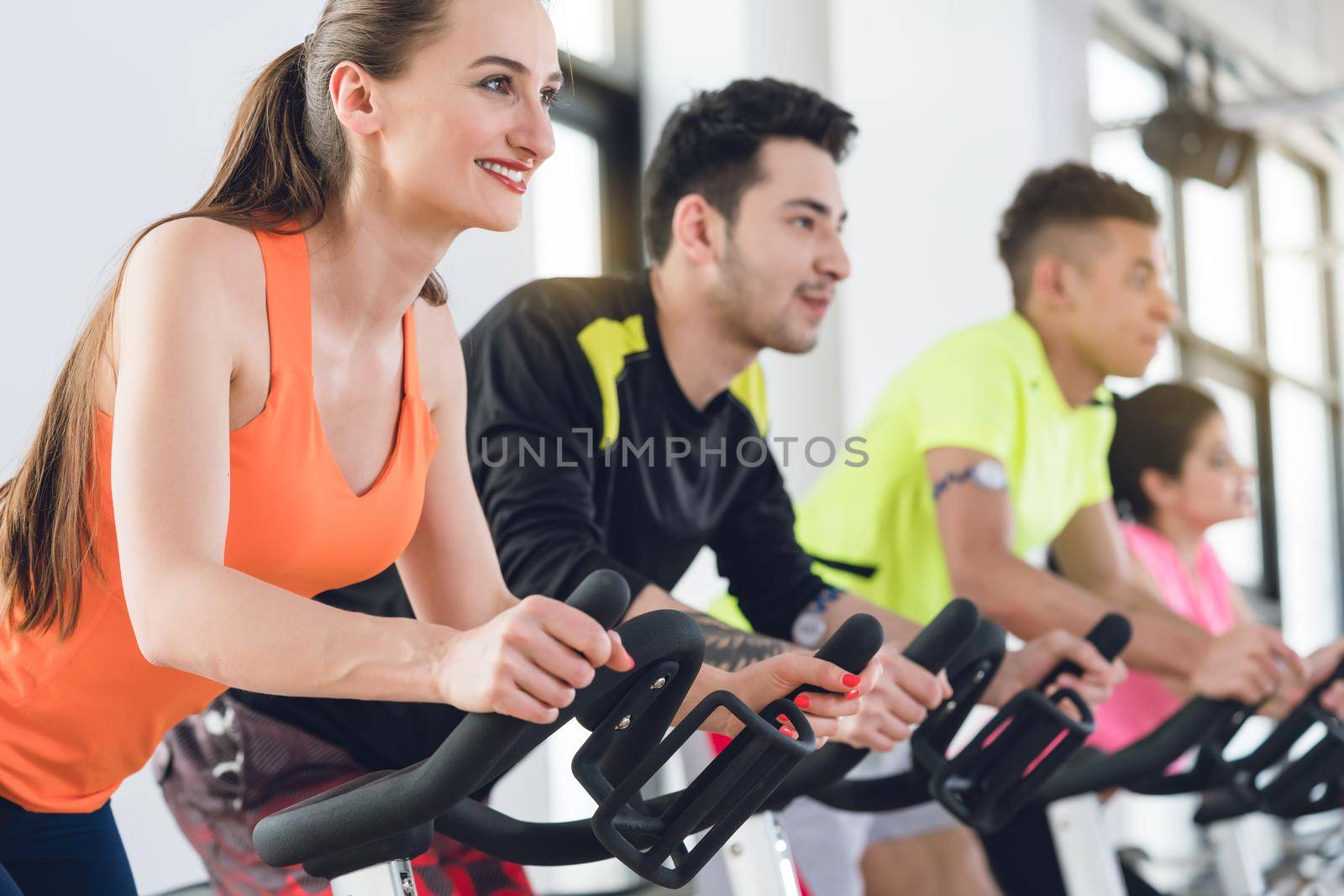 Healthy people exercising on cycle at the gym