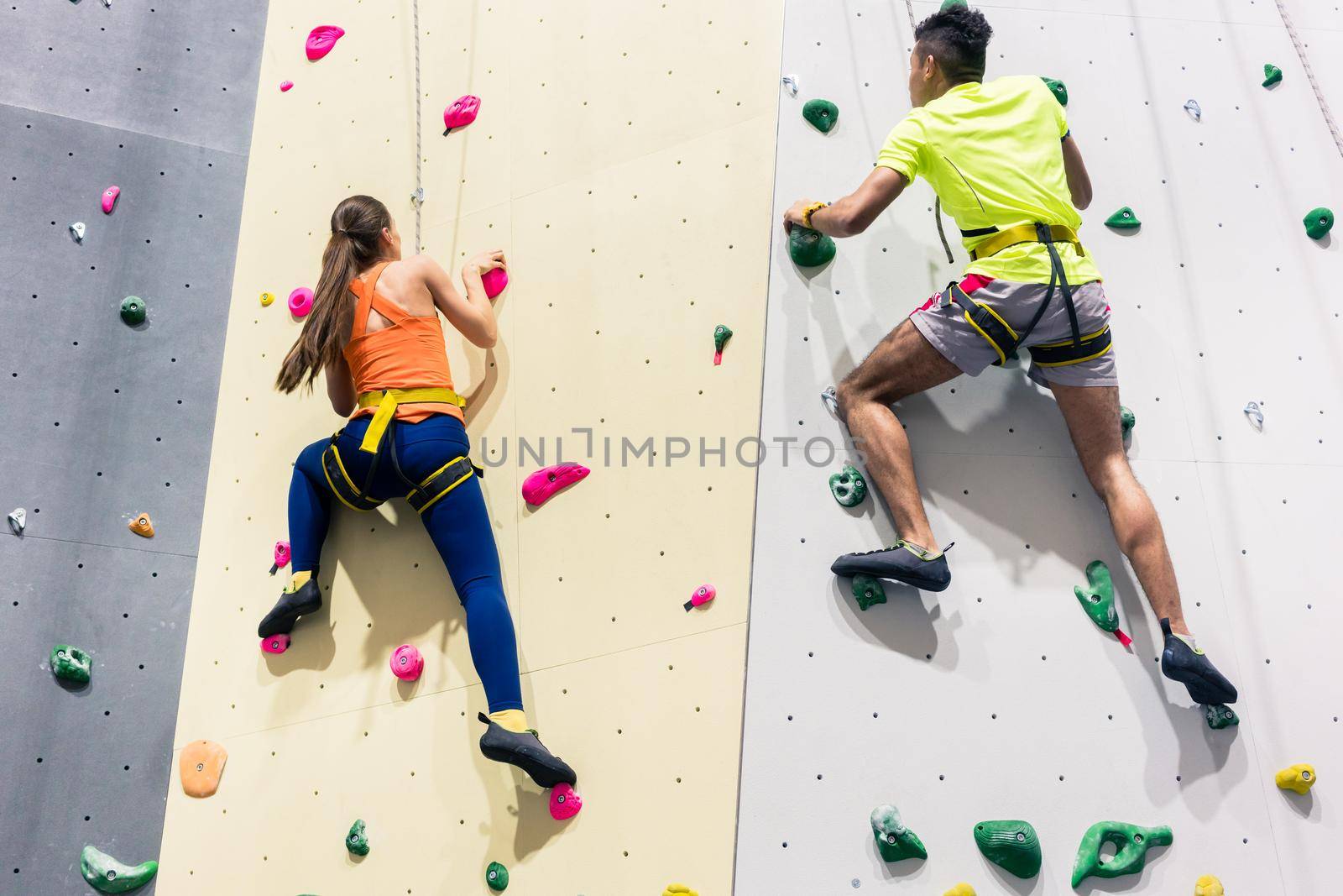 Rear view of a sporty people climbing wall