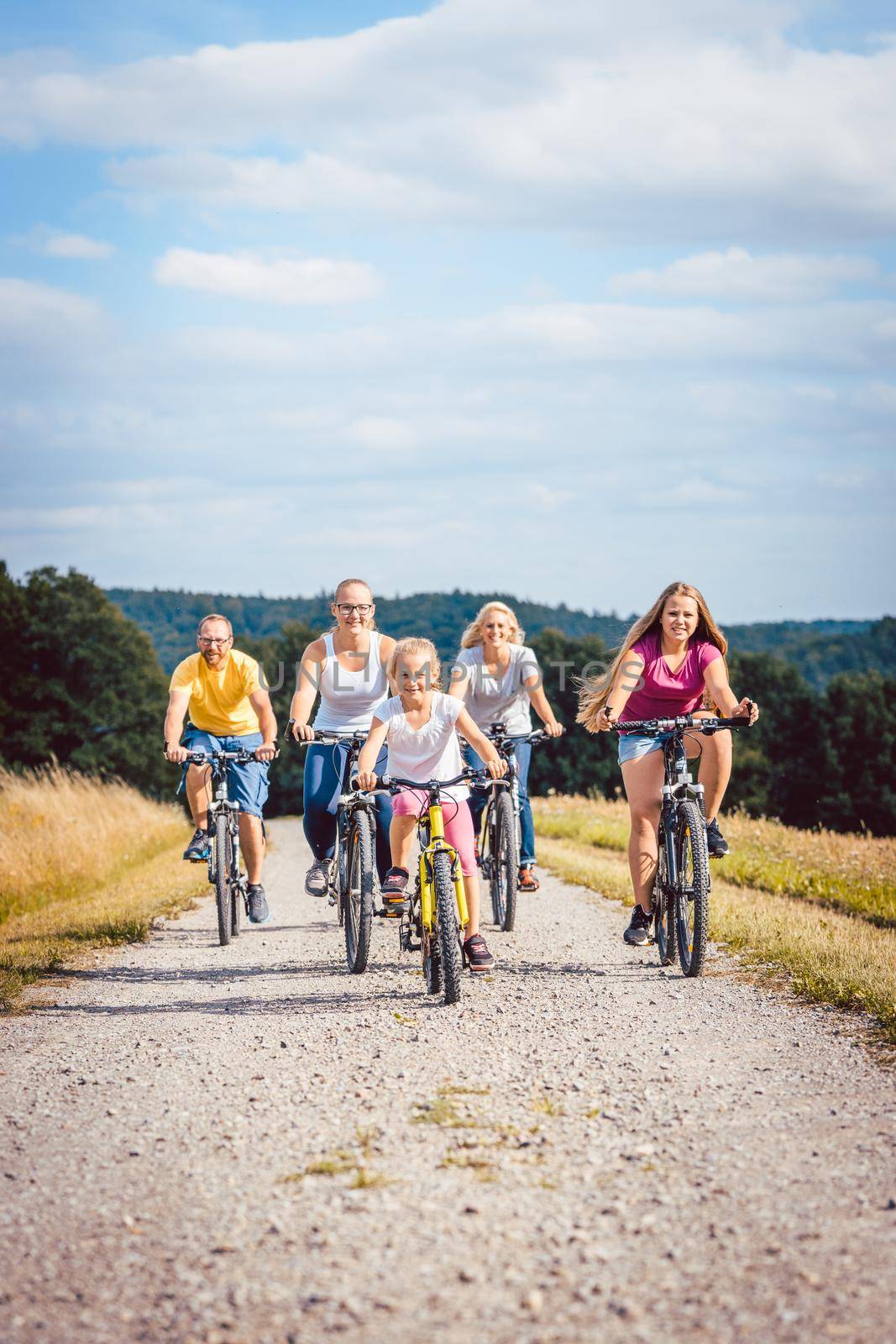 Family riding their bicycles on afternoon in the summer countryside