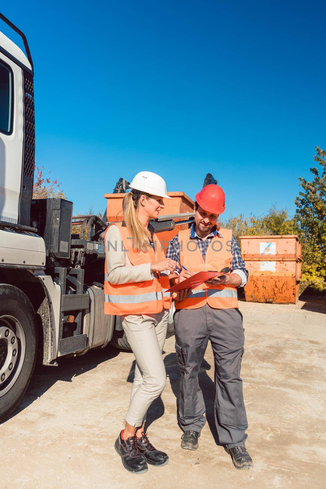 Worker signing papers to have delivered demolition rubble container by Kzenon