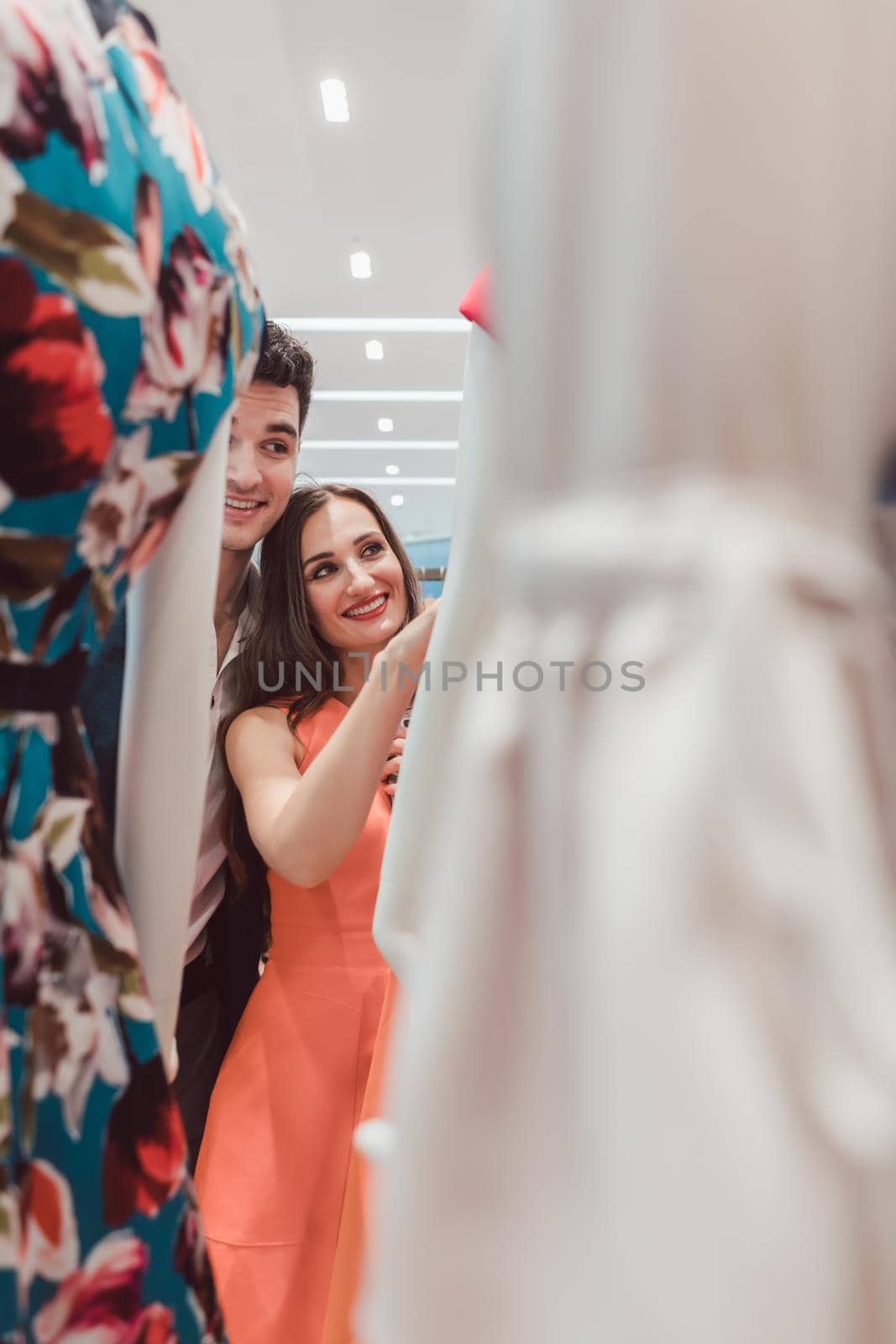 Woman and man looking at dresses on a mannequin in high fashion store