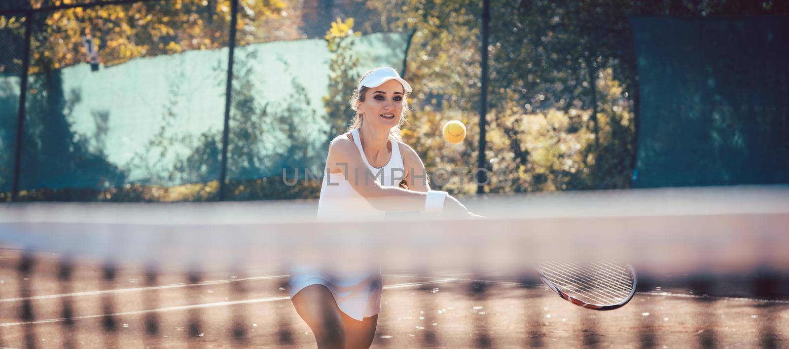Woman player getting a ball on the tennis court