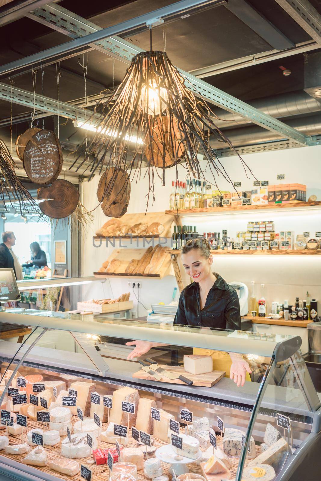 Young Sales lady at the cheese counter in a supermarket working