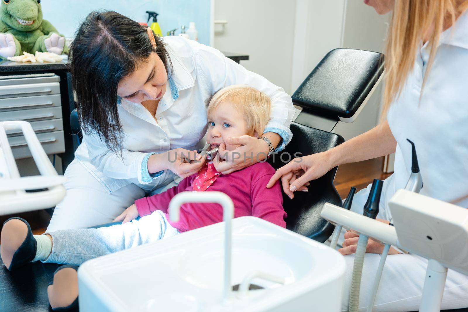 Friendly dentist checking teeth of a little child