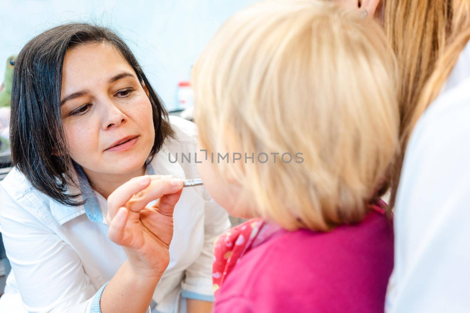 Little child watching with curiosity in mirror being treated by the dentist