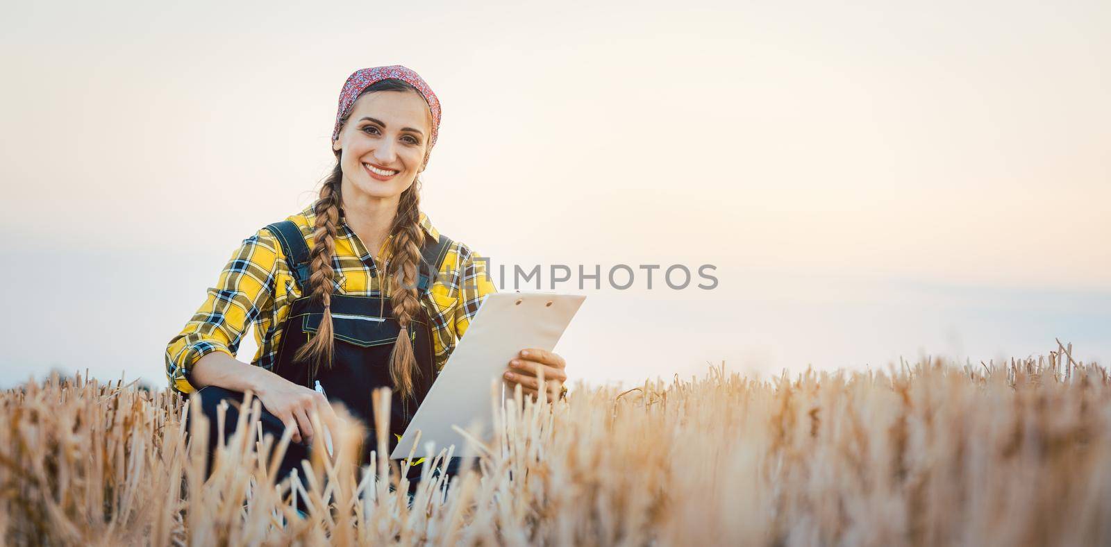 Farmer sitting on field after harvest doing crop planning for next season