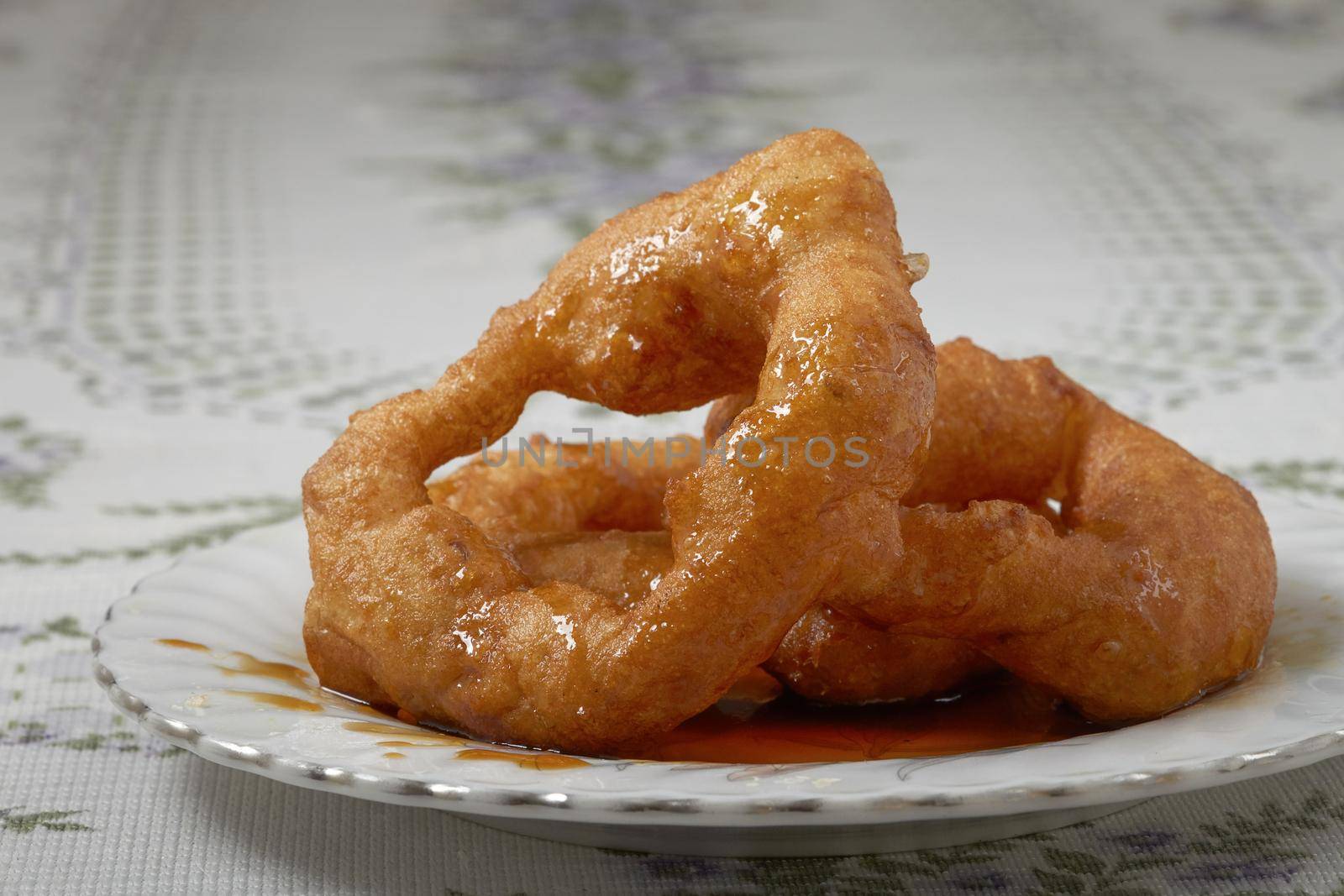 Traditional peruvian dessert Picarones. Made of sweet potato, pumpkin and wheat flour. Fried an served whit honey figs.