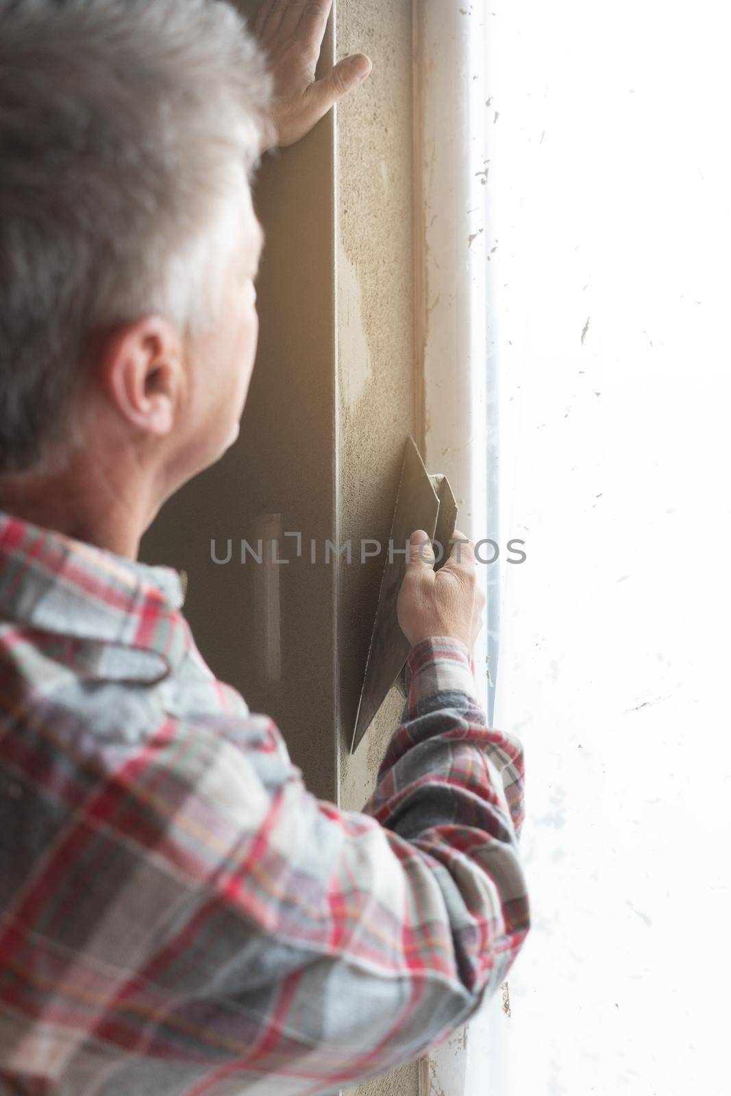 Diligent plasterer working on a window opening