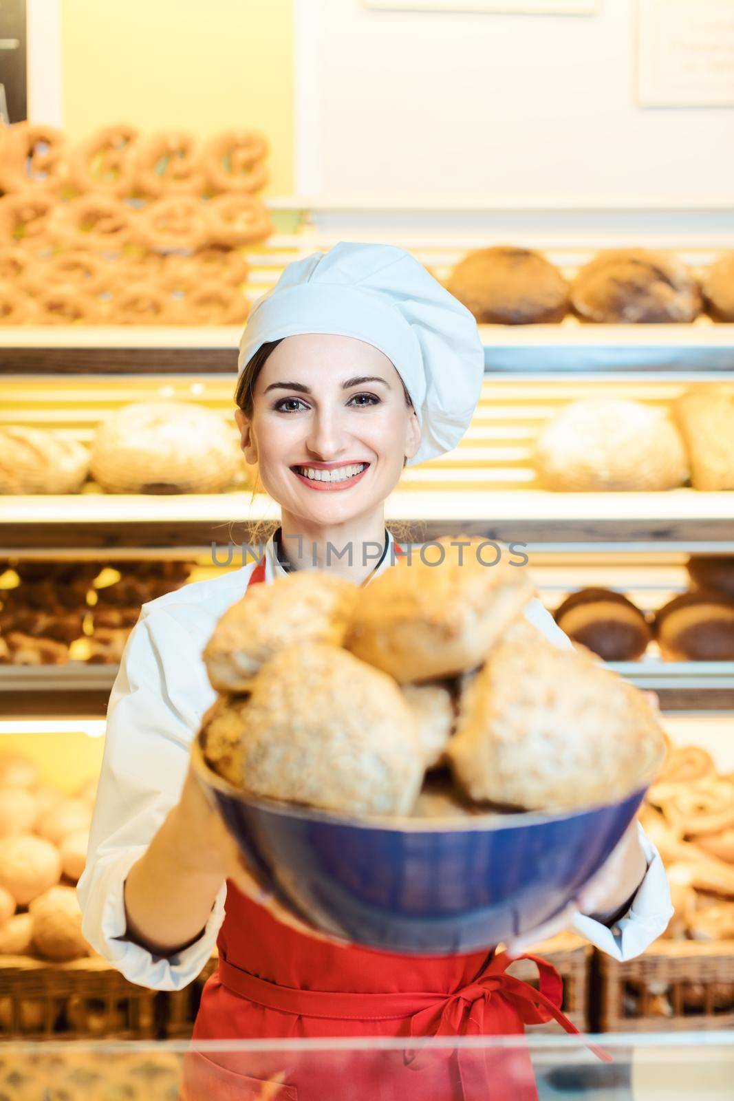 Fresh bread rolls presented by an attractive young sales woman in bakery