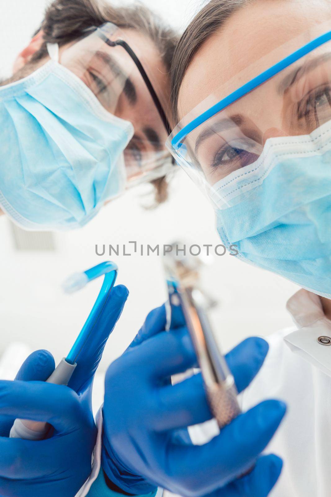 Funny dentists with their tools from point of view being a bit dangerous