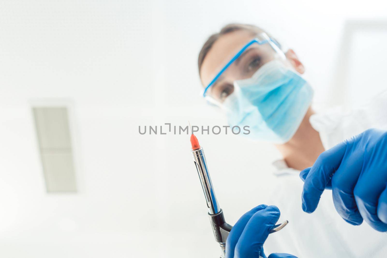 Dentist with anesthetic injection syringe from point of view by Kzenon