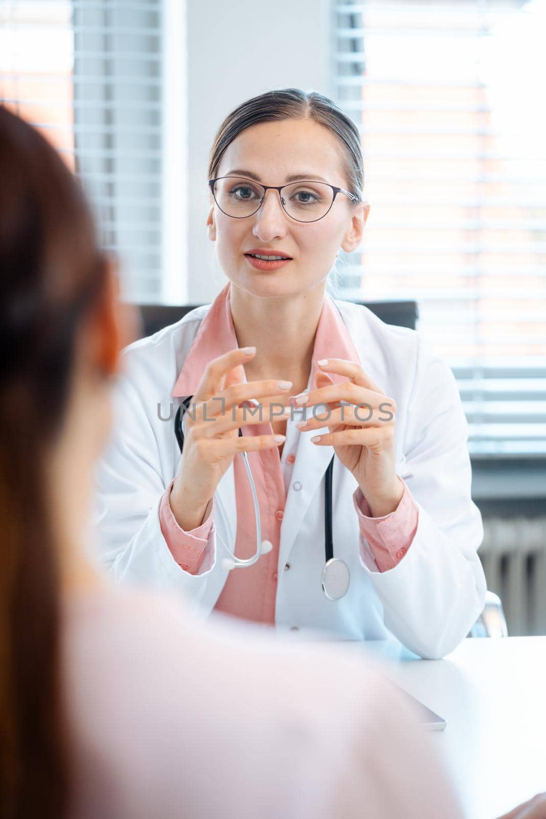 Young female doctor seeing woman patient in consultation