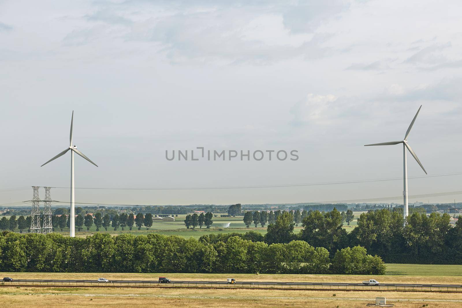 Windmills as wind turbine power generators placed within the countryside of green country of Netherlands by wondry