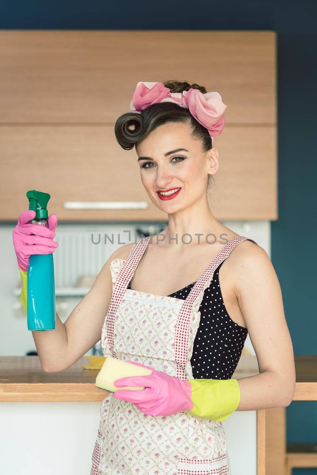 Cheerful and determined housewife cleaning the kitchen