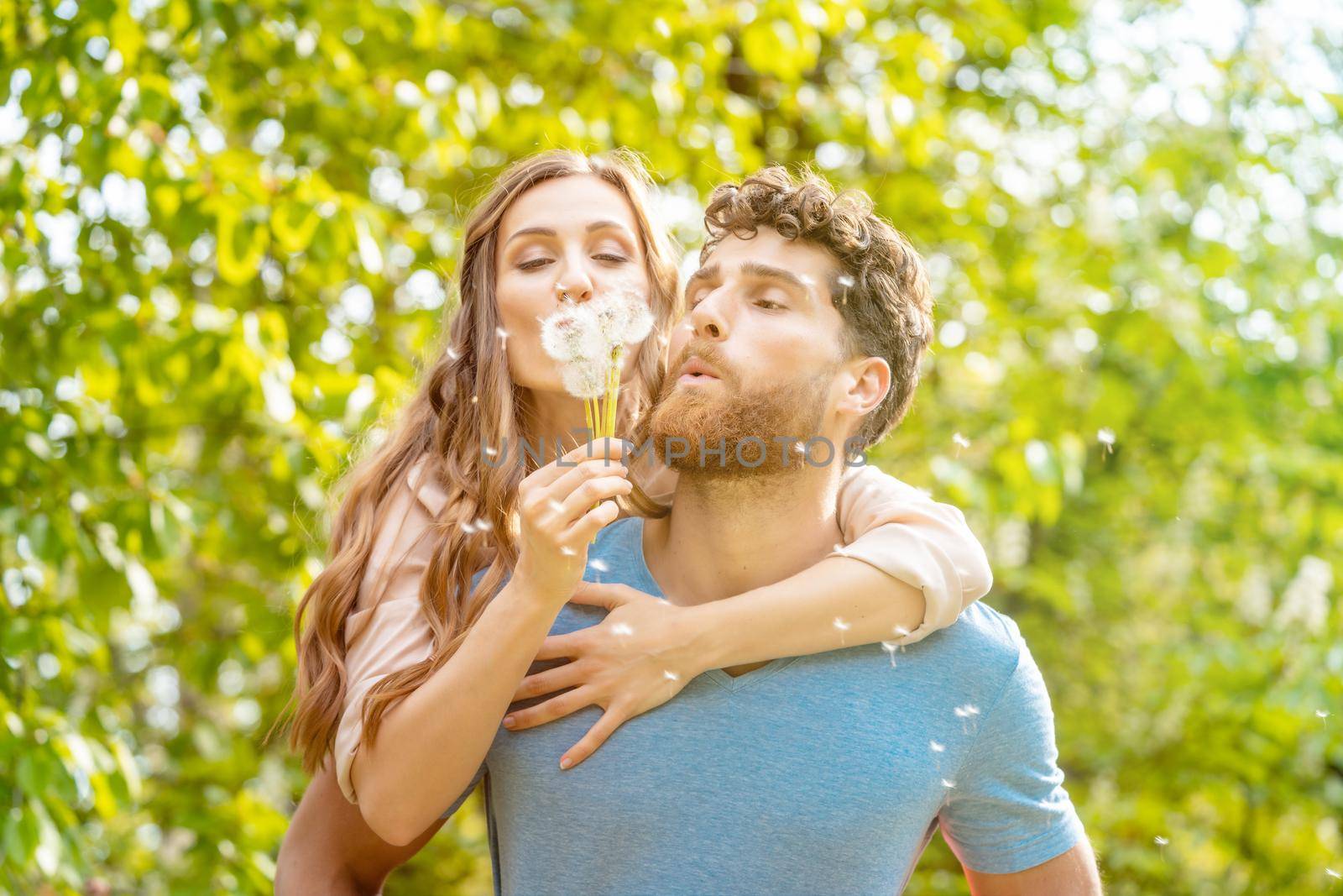 Woman and man on a meadow in romantic mood enjoying themselves and their life