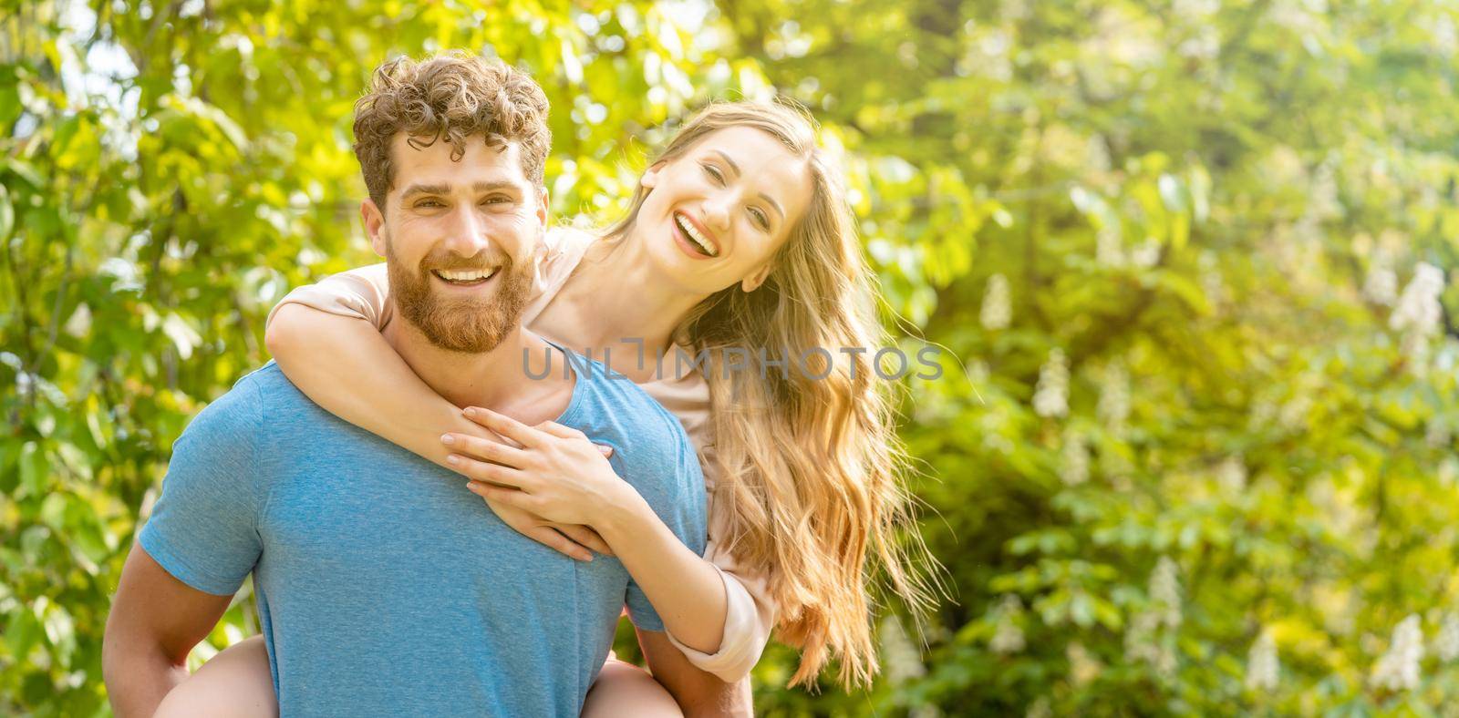 Husband is carrying his wife on his back being a strong and reliable partner