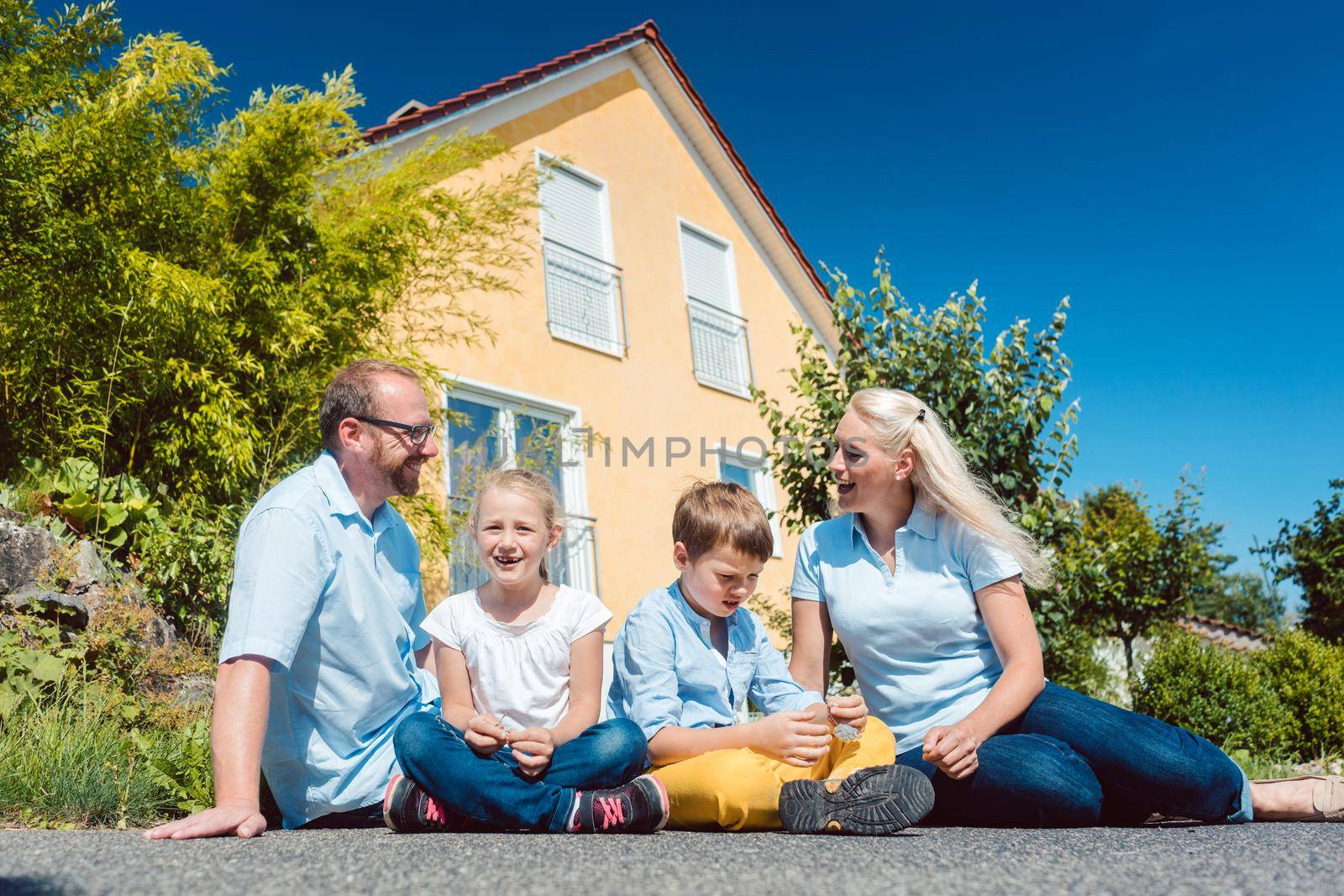 Family sitting in front of their home