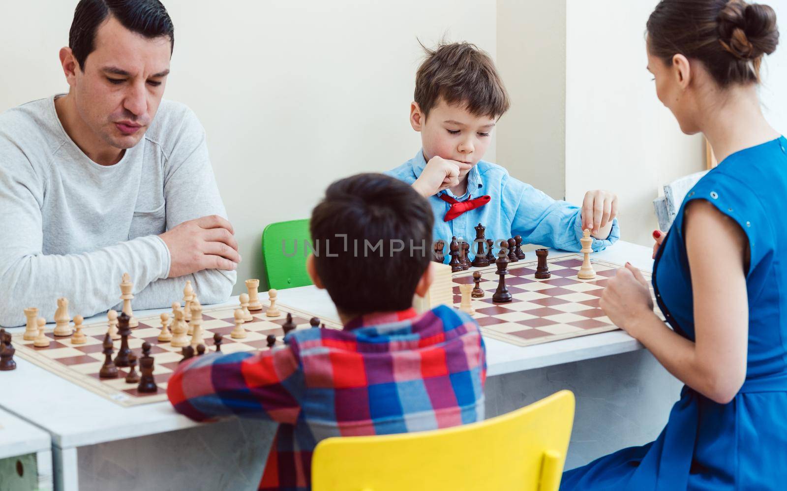 People playing a chess tournament or taking lessons