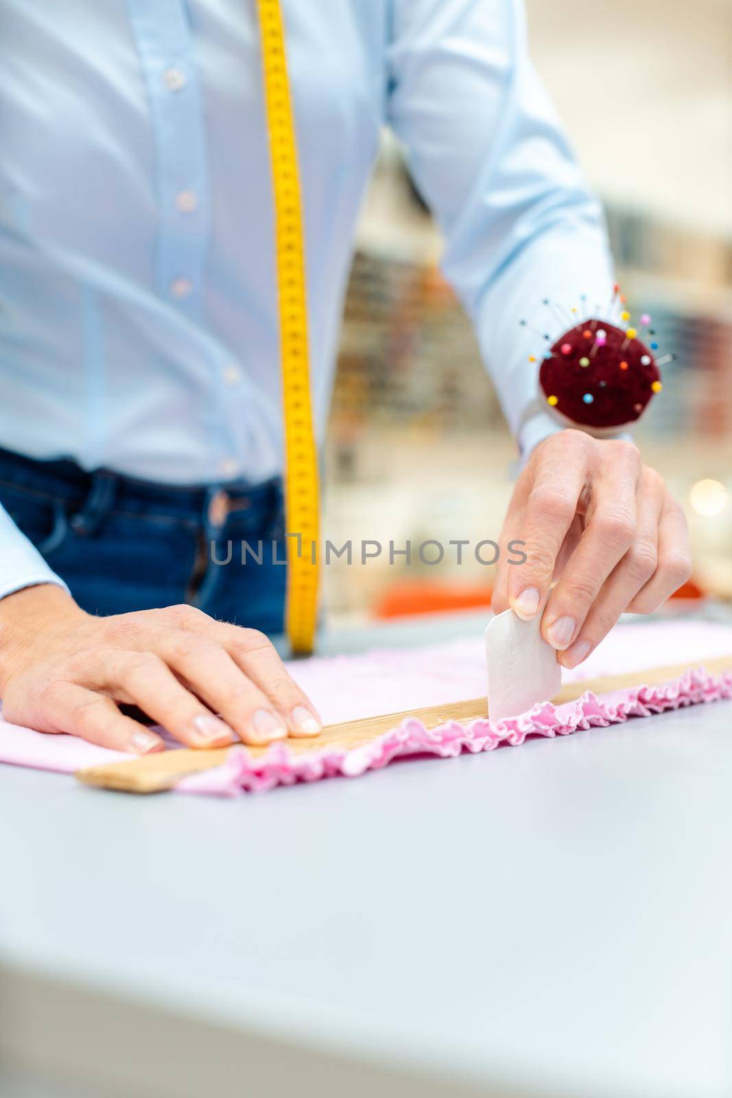 Tailor woman working with fabric by Kzenon