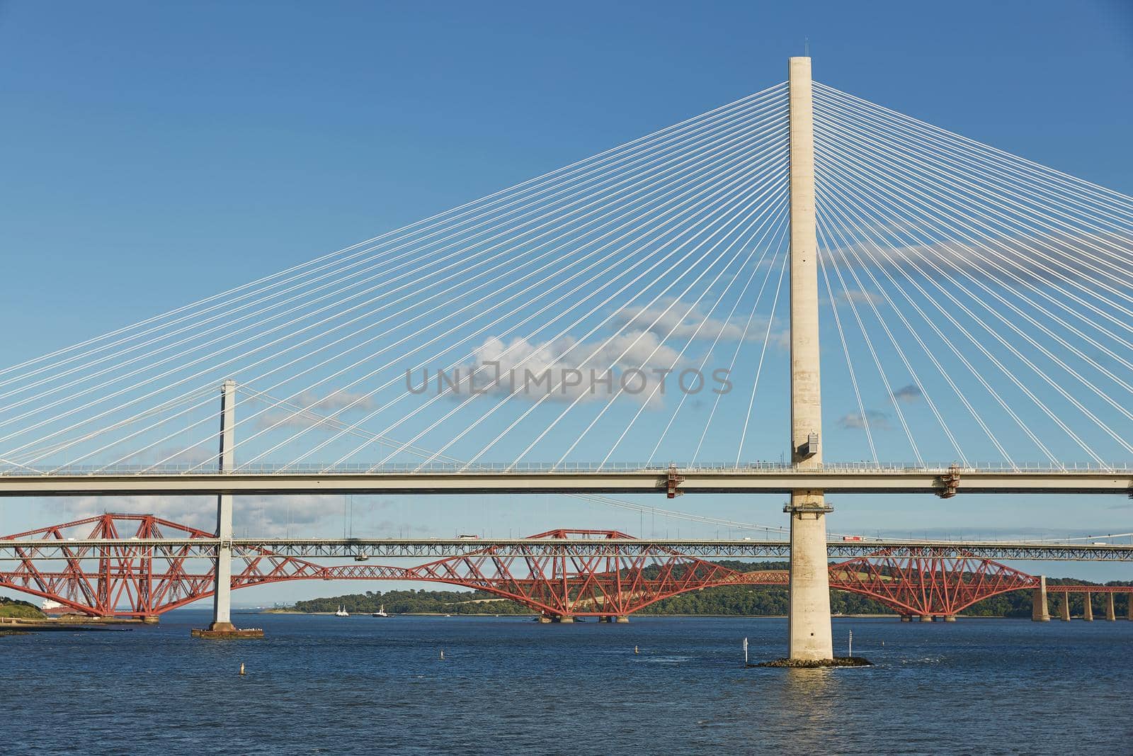 The new Queensferry Crossing bridge over the Firth of Forth with the older Forth Road bridge and the iconic Forth Rail Bridge in Edinburgh Scotland