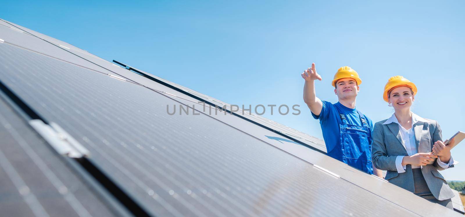 Manager and worker in photovoltaic power plant discussing maintenance of the solar farm