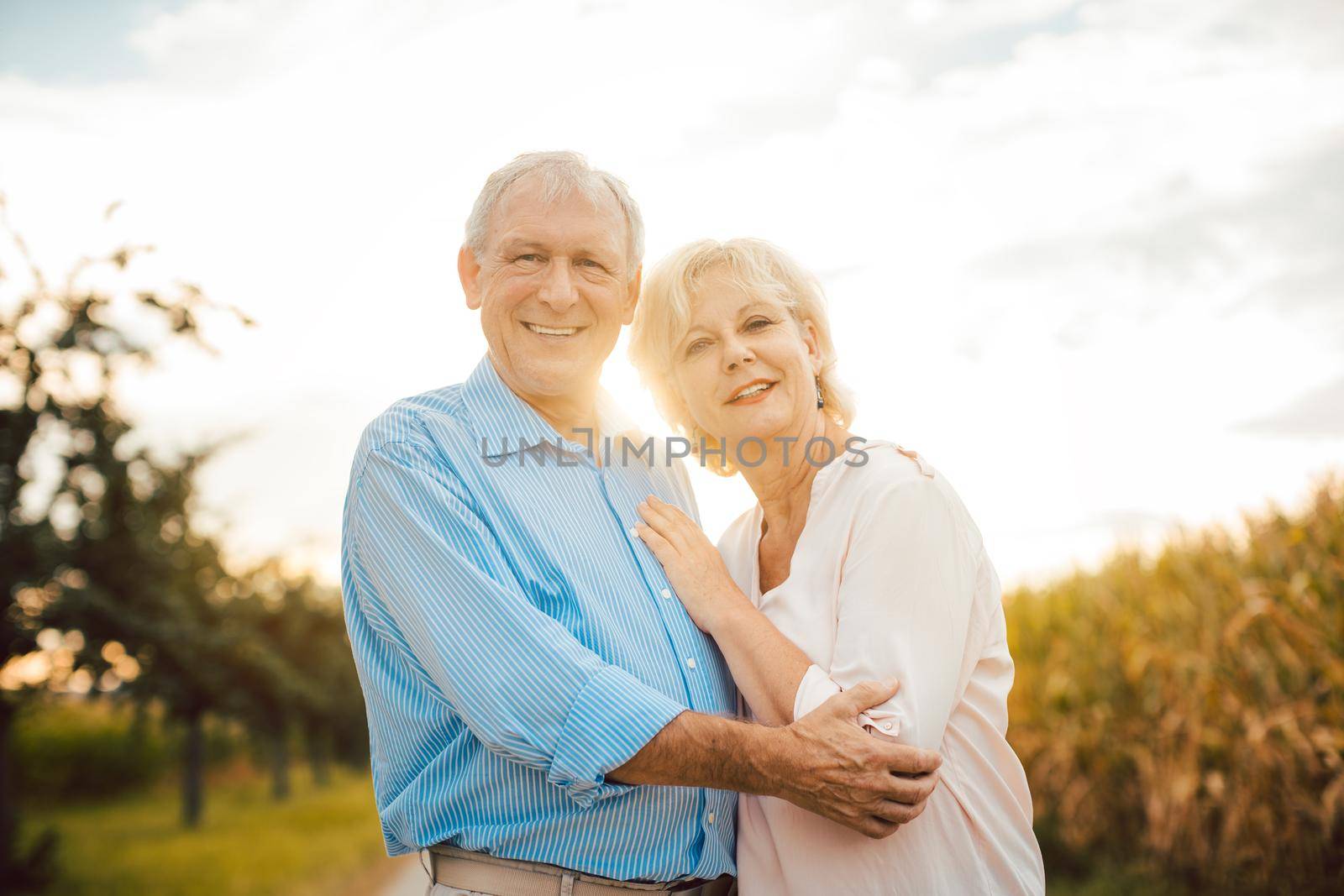 Senior couple hugging each other outdoors during sunset