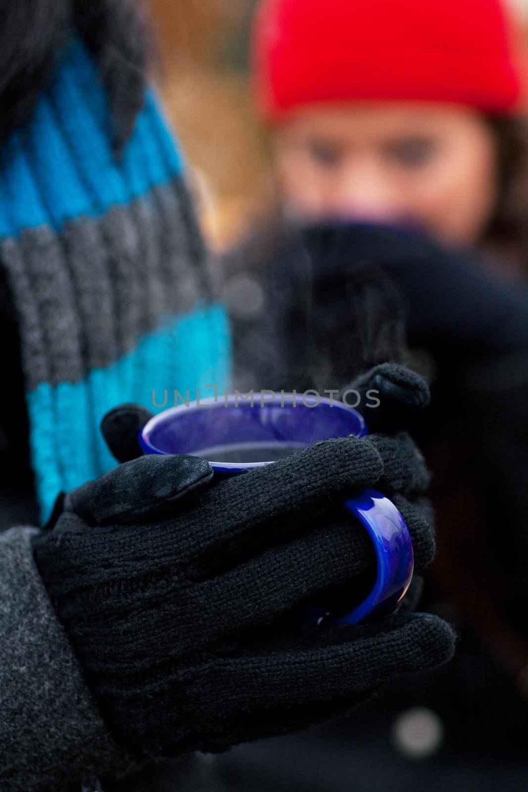 People on a Christmas market drinking punch or hot spiced wine, it is cold and they have a need to warm up