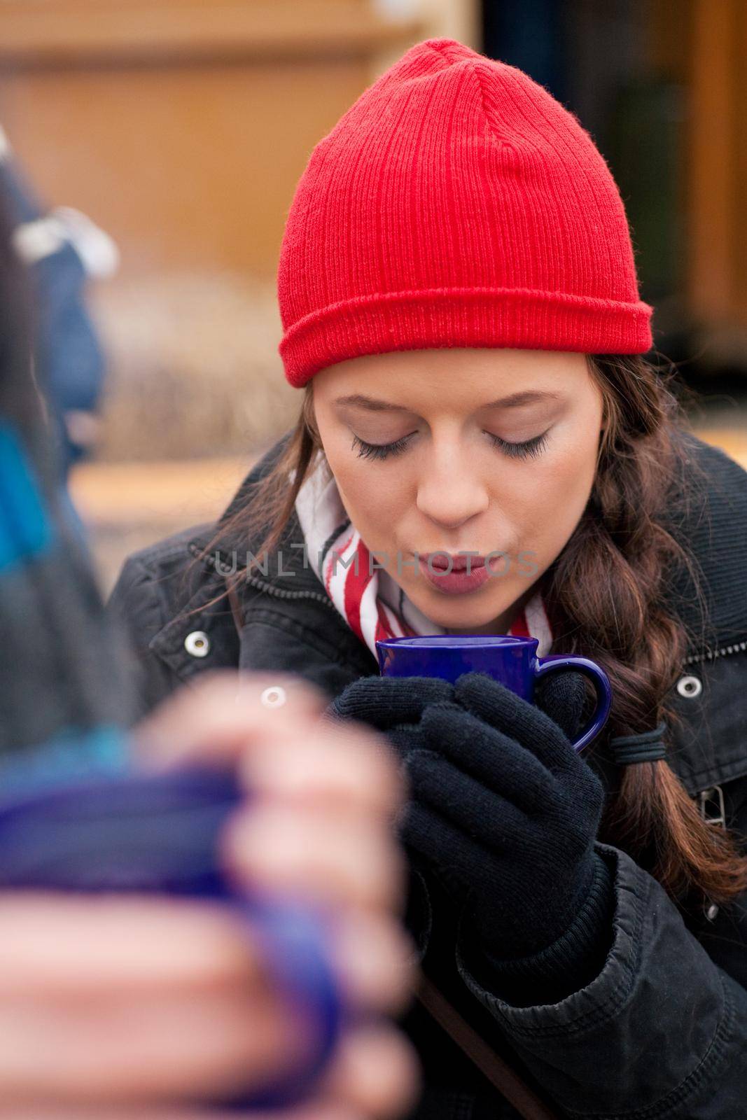 People on a Christmas market drinking punch or hot spiced wine, it is cold and they have a need to warm up