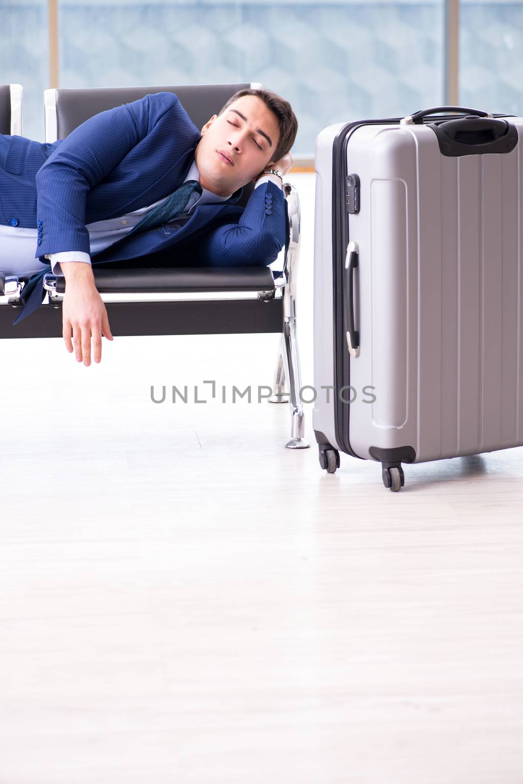Businessman waiting at the airport for his plane in business class