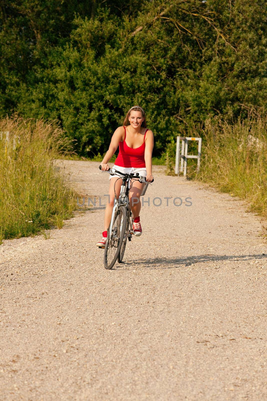 Woman riding her bicycle in summer by Kzenon