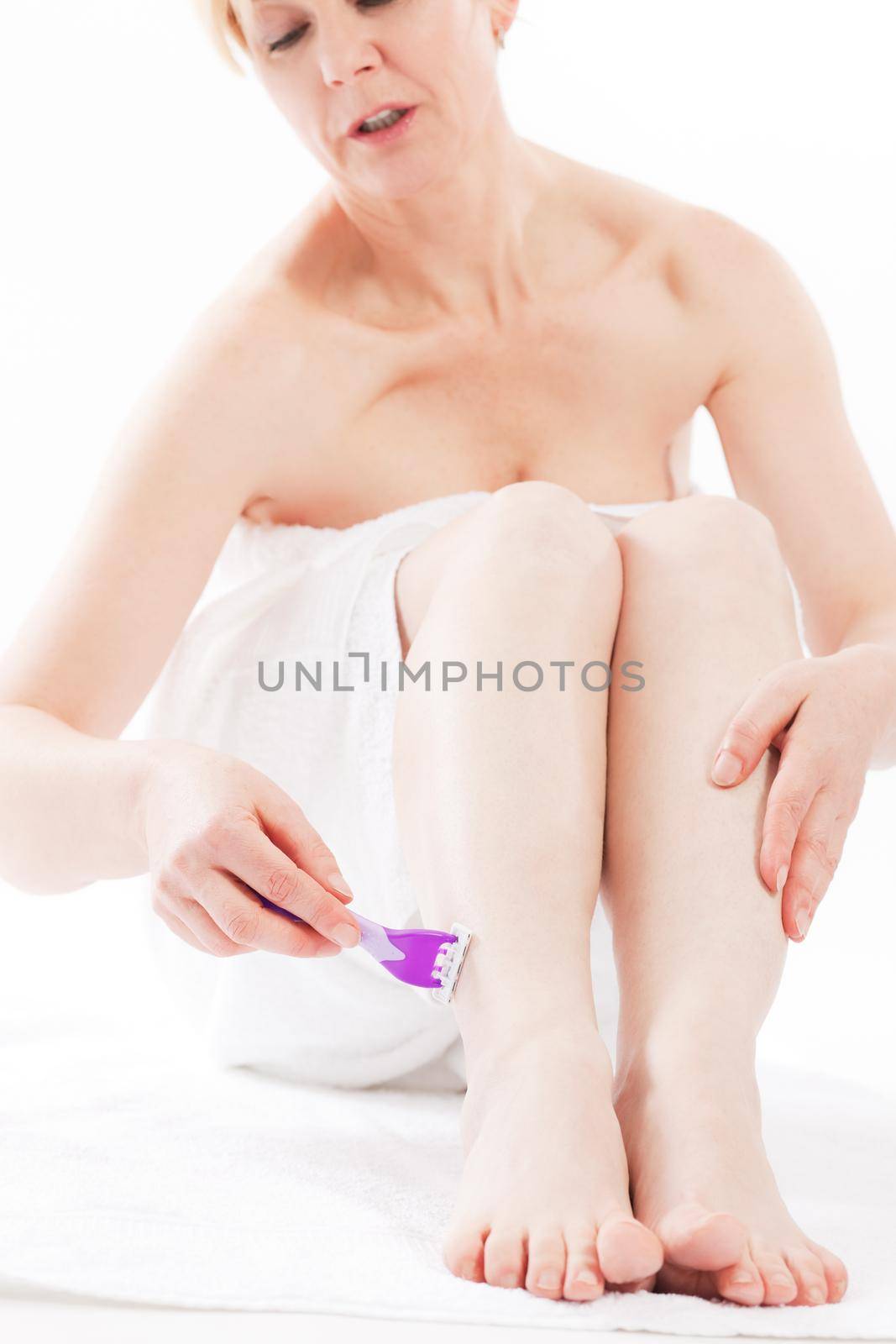 Hair removal - woman is shaving her leg