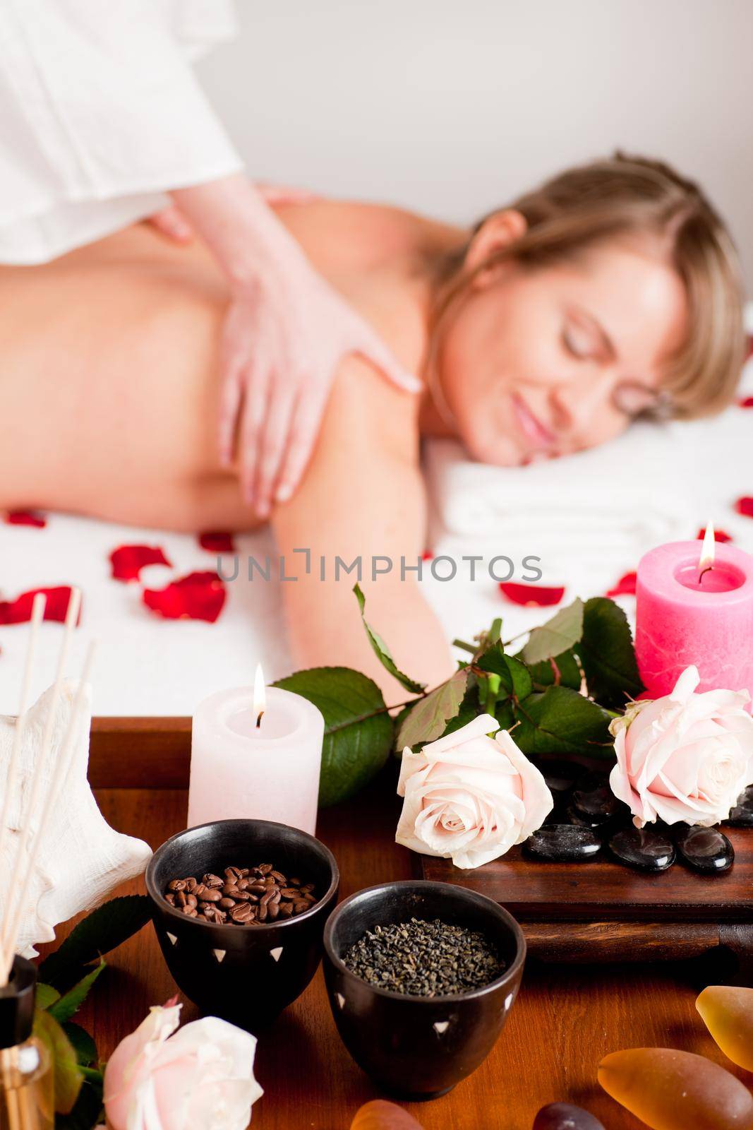 Spa - accessories in foreground, woman enjoying a back massage in the background