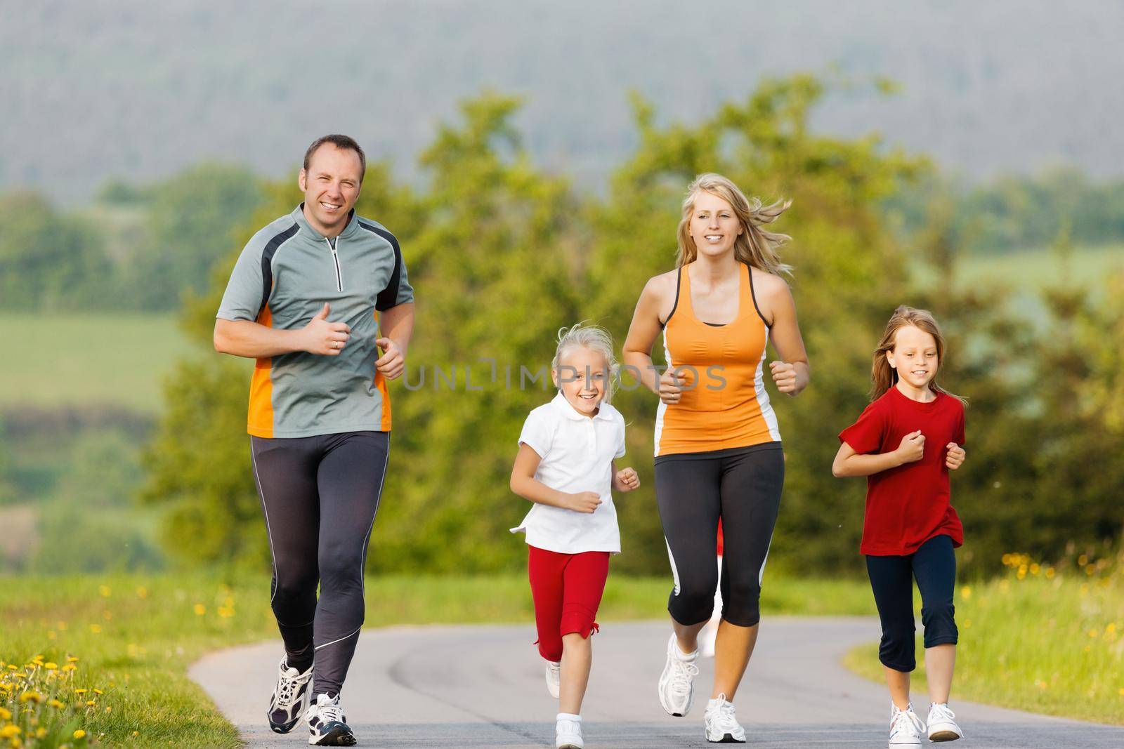 Family running for sport outdoors by Kzenon