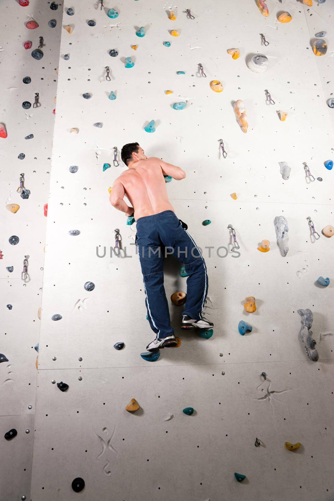 Man exercising at a climbing wall in a gym